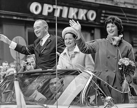 Förenta Staternas vice president Lyndon B. Johnson och två kvinnor i en öppen bil.